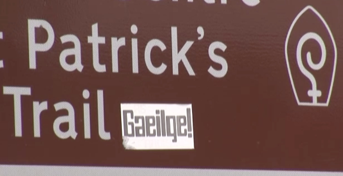 Cén fáth a bhfuil cosc ar an Ghaeilge ar chomharthaí turasóireachta anseo?